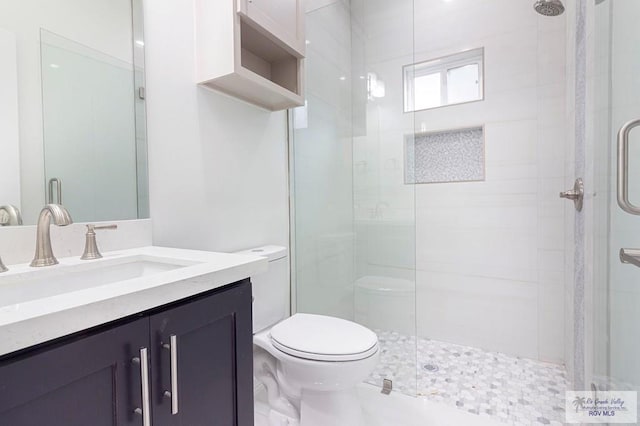 bathroom with a stall shower, vanity, and toilet