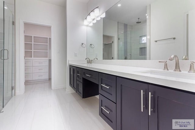 full bathroom featuring a spacious closet, a stall shower, and a sink