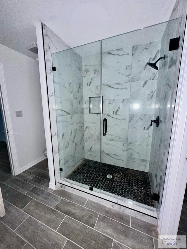 bathroom featuring walk in shower and toilet