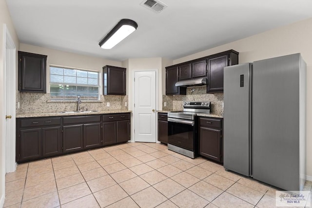2344 Munich St, Brownsville, TX 78520 - kitchen featuring stainless steel appliances, decorative backsplash, under cabinet range hood, light tile patterned floors, and light stone counters