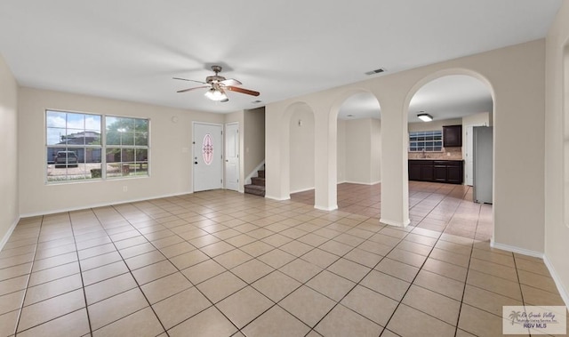 2344 Munich St, Brownsville, TX 78520 - empty room featuring a ceiling fan, light tile patterned flooring, stairs, and arched walkways