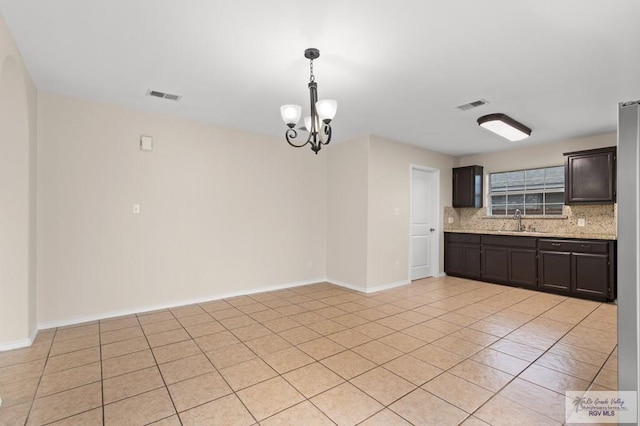 2344 Munich St, Brownsville, TX 78520 - kitchen featuring a chandelier, decorative backsplash, hanging light fixtures, dark brown cabinetry, and light tile patterned floors