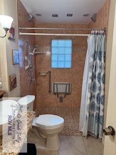 bathroom featuring toilet, vanity, a shower with curtain, and tile patterned floors