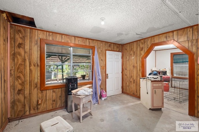 misc room with wooden walls and a textured ceiling