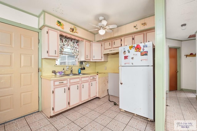 kitchen with light tile patterned floors, white fridge, ceiling fan, and sink