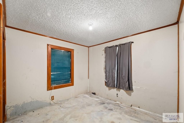 spare room featuring ornamental molding and a textured ceiling