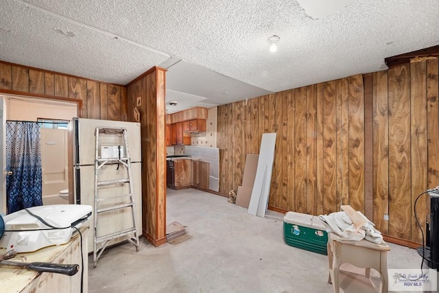 interior space featuring wooden walls and a textured ceiling