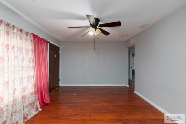 empty room featuring ceiling fan and dark hardwood / wood-style flooring