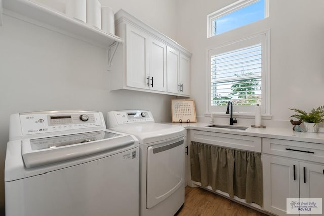 clothes washing area featuring washer and dryer, dark hardwood / wood-style flooring, cabinets, and sink