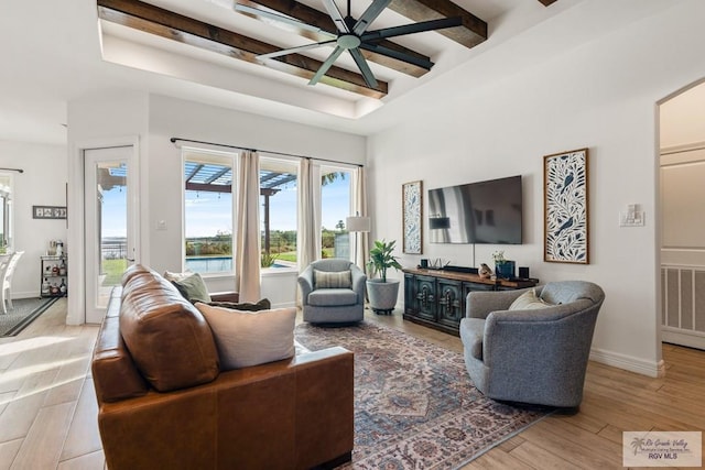 living room with beamed ceiling, ceiling fan, and light hardwood / wood-style floors