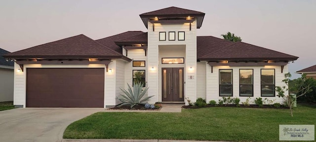 view of front of house with a yard and a garage