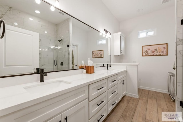 bathroom with hardwood / wood-style floors, vanity, and walk in shower