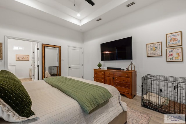 bedroom with connected bathroom, light hardwood / wood-style flooring, and ceiling fan