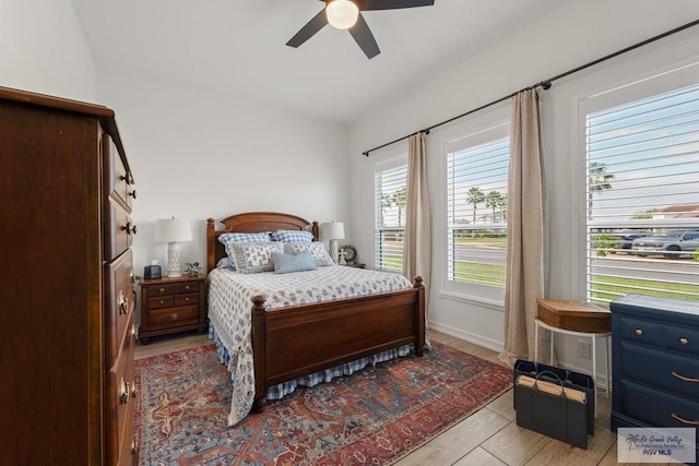 bedroom featuring light hardwood / wood-style flooring, ceiling fan, and lofted ceiling