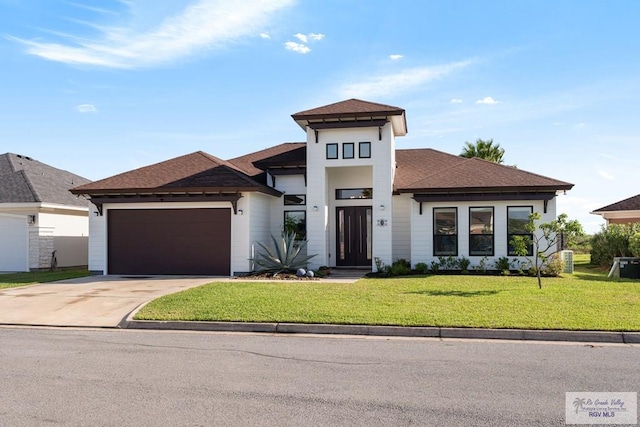 prairie-style home with a garage and a front lawn