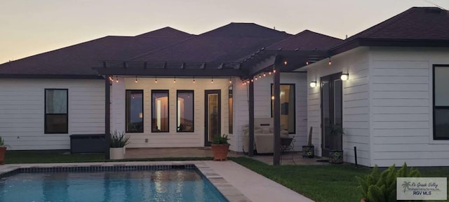 back house at dusk with a patio area