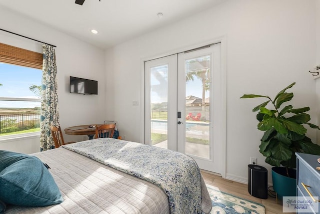 bedroom with access to outside, ceiling fan, french doors, and light hardwood / wood-style flooring