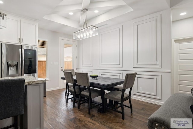 dining room with dark hardwood / wood-style floors and a raised ceiling