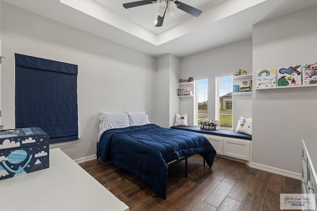 bedroom with ceiling fan and a raised ceiling