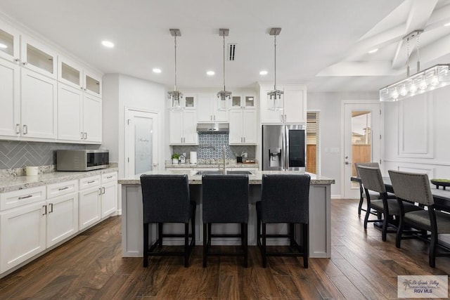 kitchen featuring white cabinetry, appliances with stainless steel finishes, and a kitchen island with sink