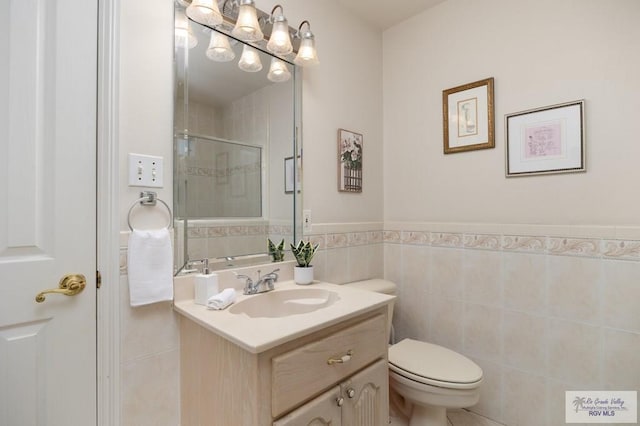 bathroom with vanity, tile walls, and toilet