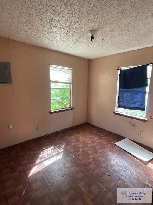 spare room featuring a textured ceiling and electric panel