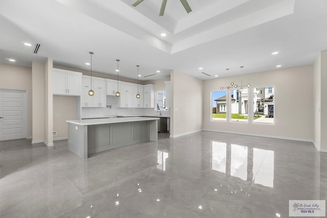 kitchen featuring sink, decorative light fixtures, a large island, ceiling fan, and white cabinets