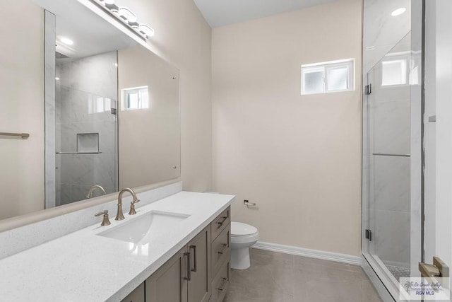 bathroom with toilet, vanity, and an enclosed shower