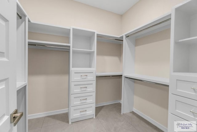 walk in closet with light tile patterned floors