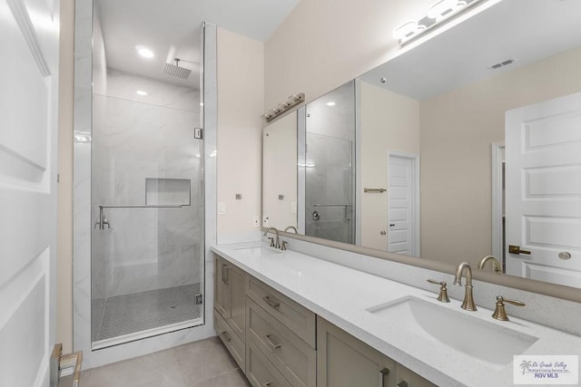 bathroom featuring vanity, tile patterned flooring, and a shower with shower door