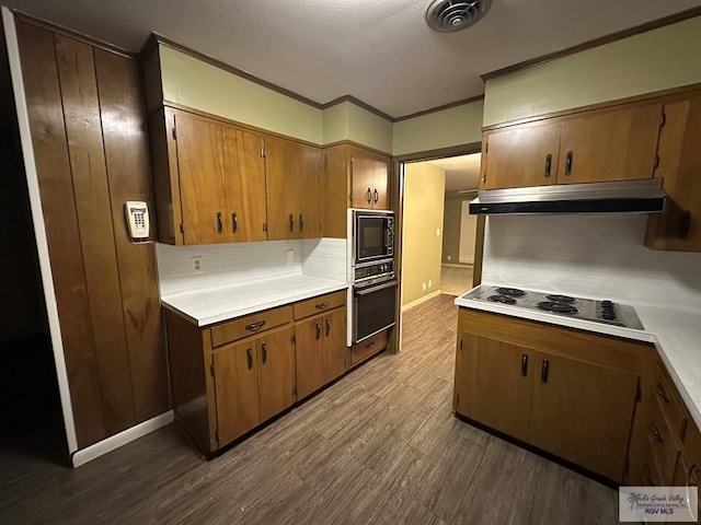 kitchen featuring hardwood / wood-style flooring, crown molding, and black appliances