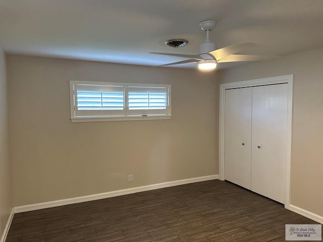 unfurnished bedroom with ceiling fan, dark hardwood / wood-style flooring, and a closet