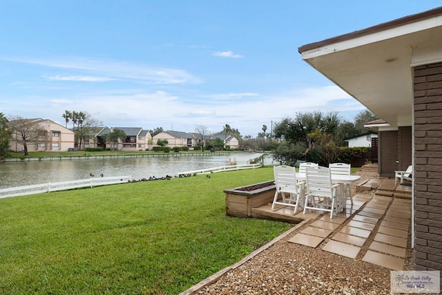 1215 Bluebonnet Dr, Brownsville, TX 78521 - view of grassy yard with a water view, outdoor dining area, and a residential view