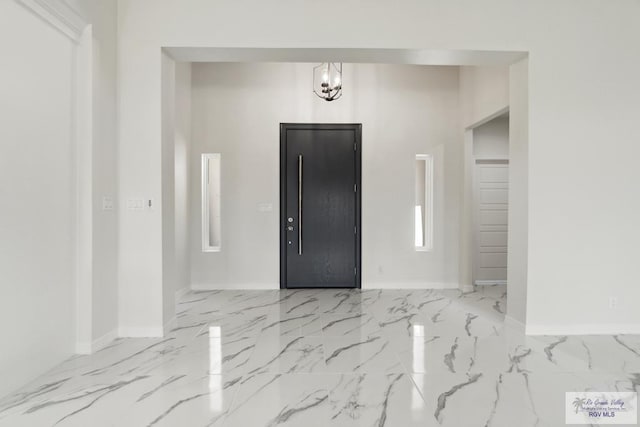 foyer entrance featuring a notable chandelier