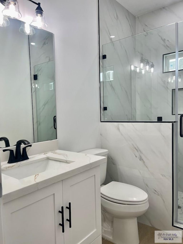 bathroom featuring vanity, an enclosed shower, and toilet