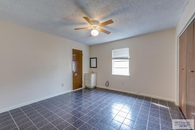 115 E Armstrong Ct, Brownsville, TX 78521 - unfurnished bedroom with a textured ceiling, dark tile patterned flooring, baseboards, a closet, and ceiling fan