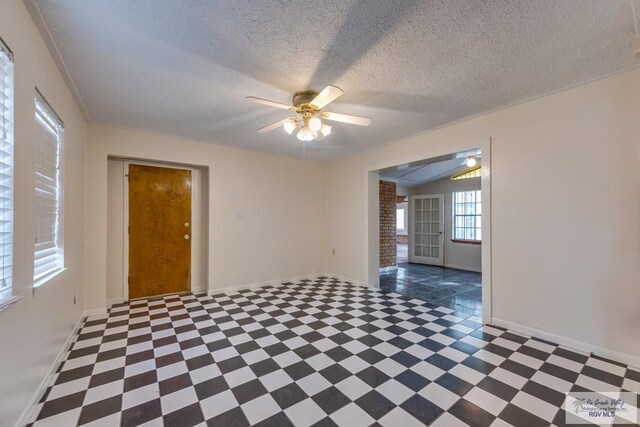 115 E Armstrong Ct, Brownsville, TX 78521 - spare room with tile patterned floors, a ceiling fan, baseboards, and a textured ceiling