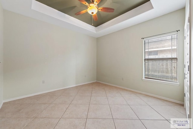 7136 Arroyo Blvd, Brownsville, TX 78526 - empty room with a raised ceiling, ceiling fan, light tile patterned floors, and baseboards