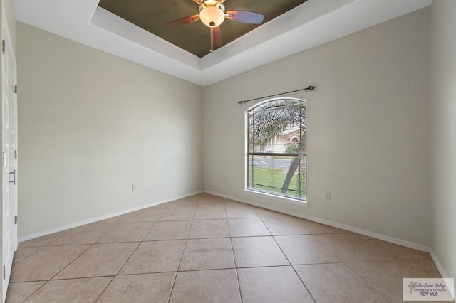 7136 Arroyo Blvd, Brownsville, TX 78526 - spare room featuring light tile patterned flooring, a tray ceiling, a ceiling fan, and baseboards