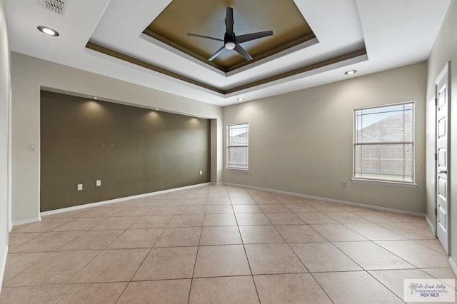 7136 Arroyo Blvd, Brownsville, TX 78526 - empty room with a raised ceiling, plenty of natural light, ceiling fan, light tile patterned floors, and recessed lighting