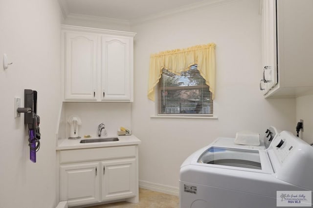 washroom featuring separate washer and dryer, a sink, baseboards, cabinet space, and crown molding