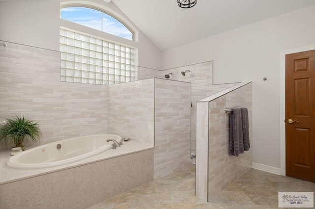 bathroom with lofted ceiling, a garden tub, and a walk in shower