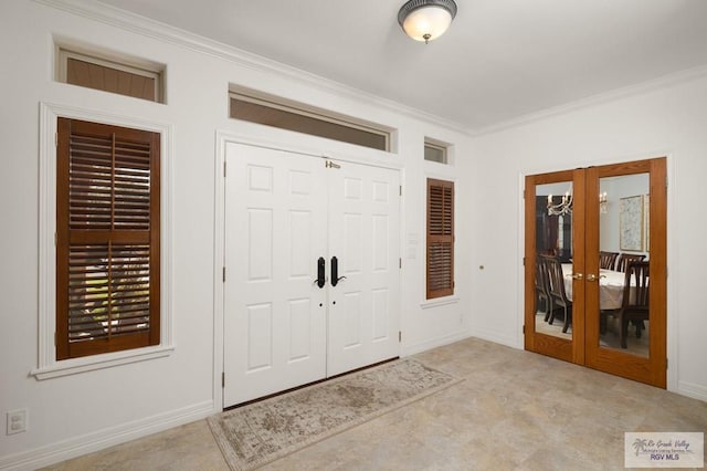 foyer entrance with baseboards, ornamental molding, and french doors