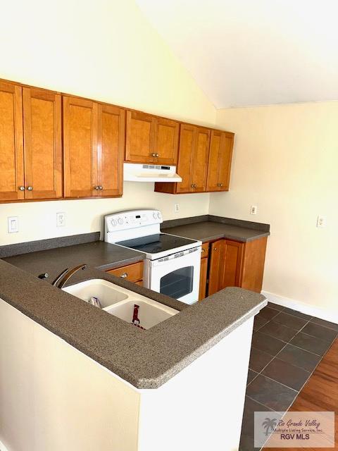 kitchen featuring sink, white electric range oven, dark tile patterned floors, kitchen peninsula, and lofted ceiling