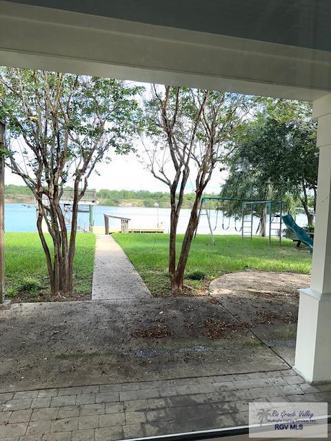 view of yard featuring a water view and a playground