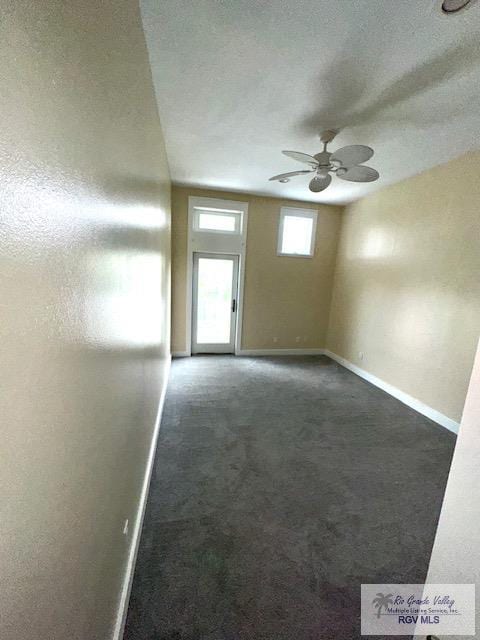 carpeted empty room with a textured ceiling and ceiling fan