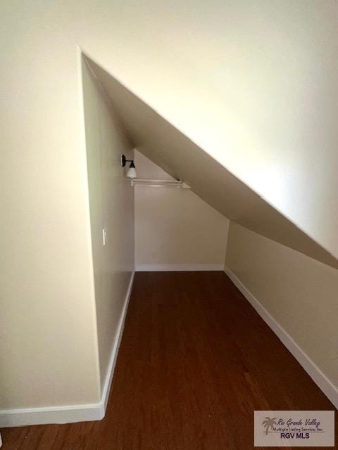 additional living space with dark hardwood / wood-style flooring and vaulted ceiling