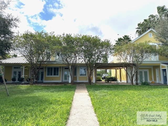 view of front of home with french doors and a front lawn