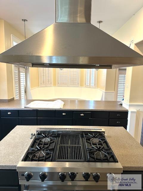 kitchen with island exhaust hood and stainless steel gas stovetop