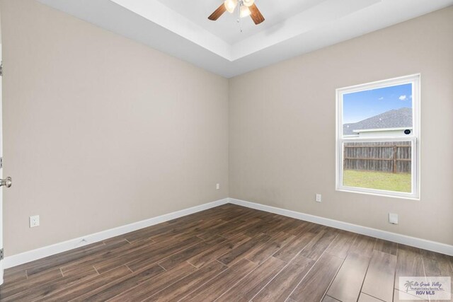 9372 Fan Palm Dr, Los Fresnos, TX 78521 - unfurnished room featuring ceiling fan, dark wood-type flooring, baseboards, and a raised ceiling
